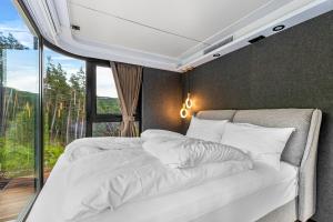 a bedroom with two white beds and a window at Sogndal Fjordpanorama - The atmosphere in Sogndal