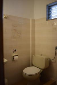 a bathroom with a toilet and a sink and a window at Alexander in Pefkochori