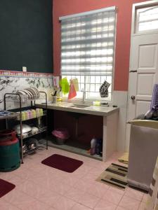 a kitchen with a sink and a desk in a room at SERI LAZUARDI 6 (MUSLIM FRIENDLY) in Tanah Merah