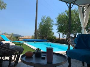 un patio con una mesa y una piscina en Casa Rosalinda en Figari