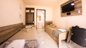 Pokój z 2 łóżkami i telewizorem z płaskim ekranem w obiekcie Open Hotel w mieście Telêmaco Borba