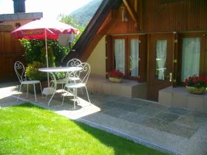 taras ze stołem, krzesłami i parasolem w obiekcie petite maison de montagne avec jardin w mieście Cier-de-Luchon +8 zdjęć