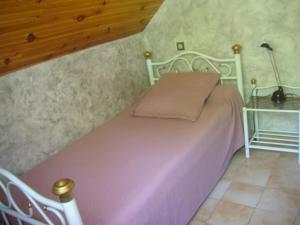 Dormitorio con cama rosa y lámpara en petite maison de montagne avec jardin, en Cier-de-Luchon