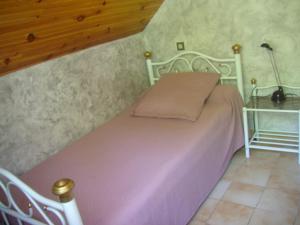 sypialnia z różowym łóżkiem z lampką w obiekcie petite maison de montagne avec jardin w mieście Cier-de-Luchon