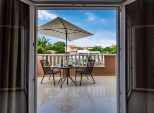 a patio with a table and chairs and an umbrella at Alexa's Sunny Days in Limenaria