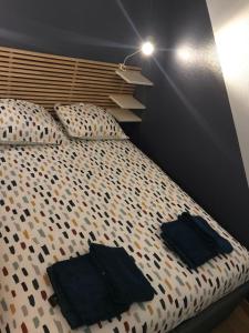 ein Schlafzimmer mit einem Bett mit schwarzen Handtüchern darauf in der Unterkunft Les gîtes de Madline, Le petit Solidor in Saint-Malo