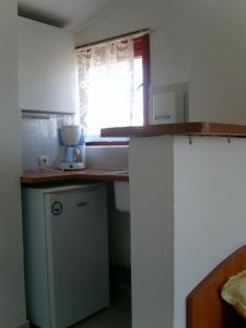 une petite cuisine avec un comptoir et une fenêtre dans l'établissement Сотирови, самостоятелни стаи, à Tchernomorets