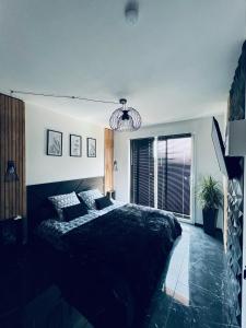 1 dormitorio con cama negra y ventana grande en Louisiana - Chambre privative, en Calais