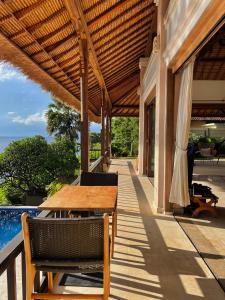 un patio al aire libre con mesa de madera y sillas en Private Luxury Villa Celagi - with large infinity pool and ocean view en Amed