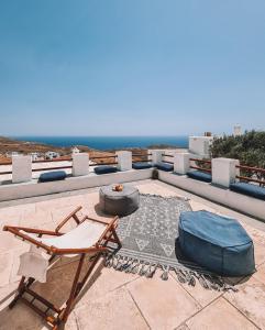 a patio with a chair and a mattress and the ocean at Villa Antigoni Serifos in Serifos Chora
