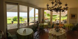 a dining room with tables and chairs and a large window at Agriturismo La Casa in Collina in Canelli