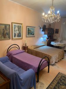 - une chambre avec 2 lits et un lustre dans l'établissement Luxury Villa Barbara, à Reggio de Calabre