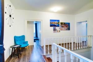 a white room with a blue chair and stairs at Divinity's - old town center in Zadar