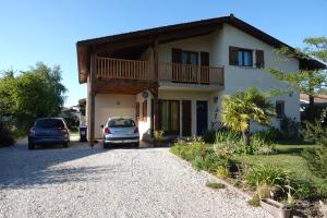 a house with cars parked in front of it at Appartement Palm'Ares in Arès