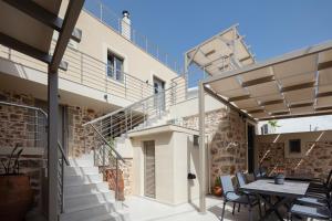 eine Terrasse mit einem Tisch und Stühlen sowie ein Gebäude in der Unterkunft "Kedros Villa" a luxury touch in Orné