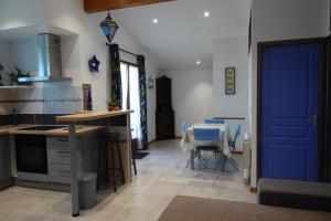 une cuisine avec une porte bleue et une table dans l'établissement Appartement Palm'Ares, à Arès 21 autres photos