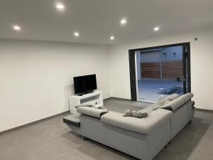 ラカノーにあるMAISON moderne avec piscine chaufféeのソファとテレビのあるリビングルーム