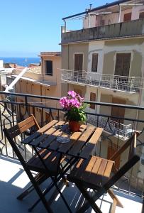 a wooden table with a potted plant on a balcony at Carpe Diem Apartments in Castellammare del Golfo