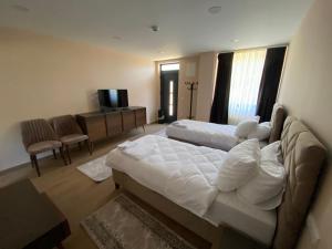 a hotel room with two beds and a flat screen tv at Apartmani Nešković Foča in Foča