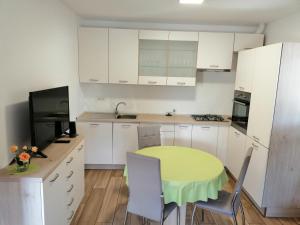 a kitchen with a table and a yellow table and chairs at Deno in Podgrad