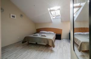 ein kleines Schlafzimmer mit einem Bett und einem Spiegel in der Unterkunft Butukas Nidai in Nida