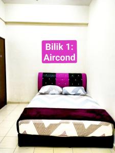 1 dormitorio con 1 cama con un cartel rosa en la pared en Homestay Kuala Terengganu near Batu Burok, Hospital HSNZ, KTCC Mall, Drawbridge C, en Kuala Terengganu