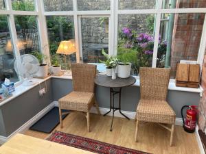 a room with a table and two chairs and a window at Parsnips House BnB Glastonbury in Glastonbury
