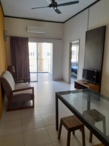 a living room with a glass table and a chair at 8pax Gold Coast Morib Resort - Banting Sepang KLIA Tanjung Sepat ebaa in Banting