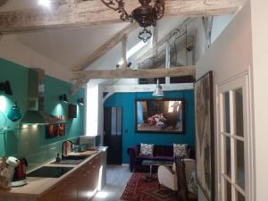 a kitchen with blue and green walls and a sink at LE LOFT DE LA SALAMANDRE SARLAT in Sarlat-la-Canéda
