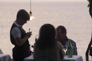 a man talking to a woman at a table with a cell phone at Costa Dorada in Cala Gonone