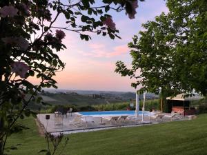a swimming pool with a group of chairs around it at Agriturismo La Casa in Collina in Canelli