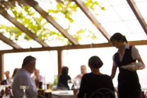 a woman standing in a restaurant with a group of people at Costa Dorada in Cala Gonone