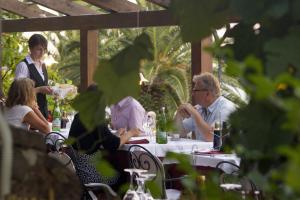 a group of people sitting at a table in a restaurant at Costa Dorada in Cala Gonone