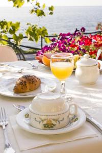 a table with a plate of food and a glass of orange juice at Costa Dorada in Cala Gonone