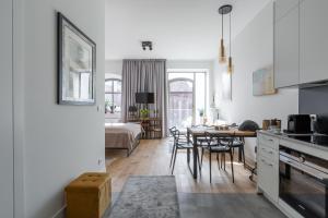 kuchnia i salon ze stołem i krzesłami w obiekcie Apartament Słoneczny - Młyn Maria - Art Apartments we Wrocławiu