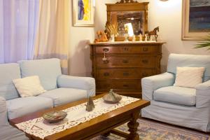 a living room with two white couches and a coffee table at Costa Dorada in Cala Gonone