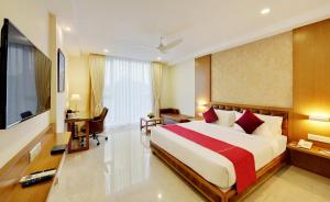 La Sara Gateway في بانغالور: غرفة نوم بسرير كبير وتلفزيون بشاشة مسطحة