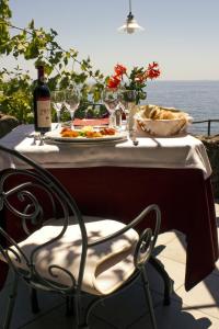 a table with a plate of food and a bottle of wine at Costa Dorada in Cala Gonone