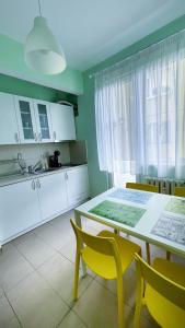 a kitchen with a table and yellow chairs in a room at IMG Apartment in Sofia