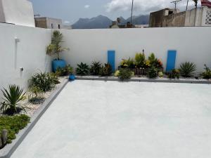 a swimming pool next to a white wall with plants at Riad Didiss Tetouan in Tetouan