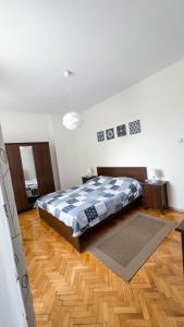 um quarto com uma cama e piso em madeira em IMG Apartment em Sófia