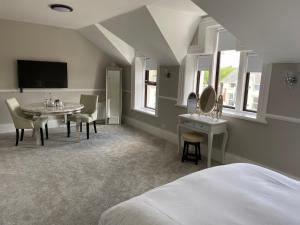 a bedroom with a bed and a table and a tv at The Imperial Garvagh in Garvagh