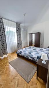 a bedroom with a bed with a blue and white blanket at IMG Apartment in Sofia