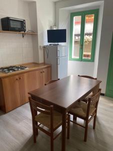 kuchnia ze stołem, krzesłami i lodówką w obiekcie Villa Verde w mieście Valsolda