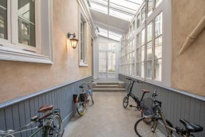 Trois vélos sont garés dans un couloir avec fenêtres. dans l'établissement Superbe Appartement Calme 85m², à deux pas du Centre, à Nantes