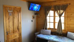 a bedroom with a bed and a tv on the wall at Entre Viñedos in Ciudad Lujan de Cuyo
