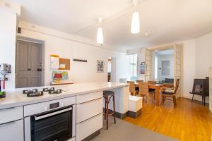 cocina con encimeras blancas y sala de estar. en Superbe Appartement Calme 85m², à deux pas du Centre, en Nantes