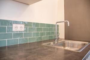 a kitchen with a sink and green tiles on the wall at Superbe Appartement Calme 85m², à deux pas du Centre in Nantes