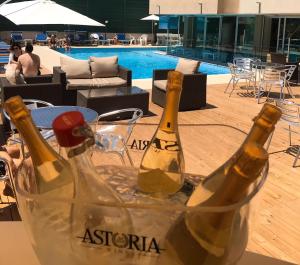 里米尼的住宿－艾普吉奧酒店，两瓶葡萄酒放在泳池旁的篮子里