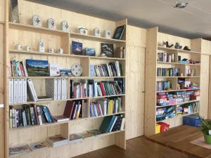 eine Bibliothek mit Holzregalen mit Büchern in der Unterkunft Glüxplatzl GmbH Appartements am Wald in Sankt Martin am Tennengebirge
